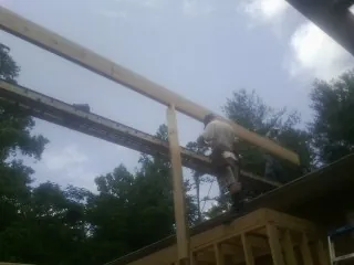 Carpenter setting a ridge beam over a new addition frame — Ice Dam Removal by Roofing Brothers in Delavan