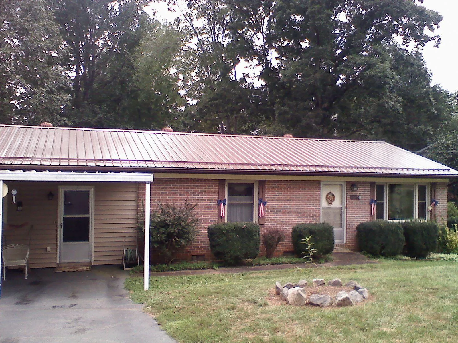 Bronze metal roof and carport on a brick ranch home — Roof Repair work by our crew in Delavan